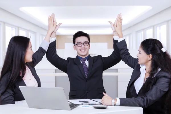 Happy business partners raising hands up — Stock Photo, Image