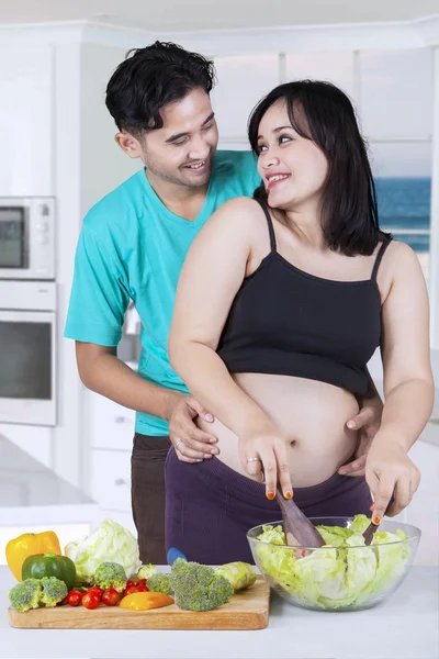 Casal feliz preparando salada juntos — Fotografia de Stock