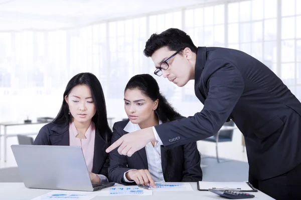 Uomo che punta al computer portatile in riunione di lavoro — Foto Stock