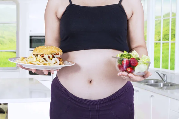 Mujer embarazada y alimentos de elección — Foto de Stock