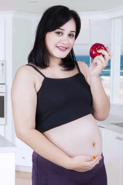 Femme enceinte tient pomme rouge — Photo