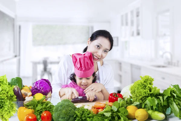 Menina bonita aprende a preparar legumes — Fotografia de Stock
