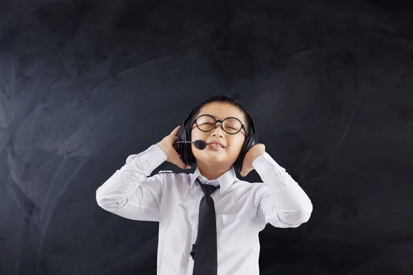 Schoolboy wearing headphones in class — Stock Photo, Image