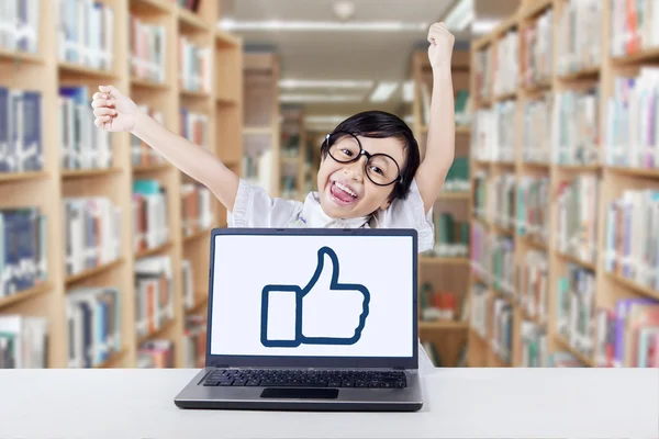 Small girl with laptop raise hands in library — Stock Photo, Image