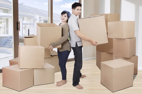 Dos parejas levantando cartones en casa — Foto de Stock