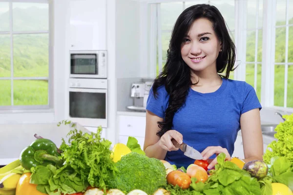 Young woman cooks fresh vegetables — Stock Photo, Image
