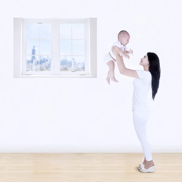 Asiatico madre lifting suo bambino in aria sopra testa — Foto Stock