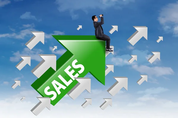 Empresário senta-se na seta com palavra de vendas — Fotografia de Stock