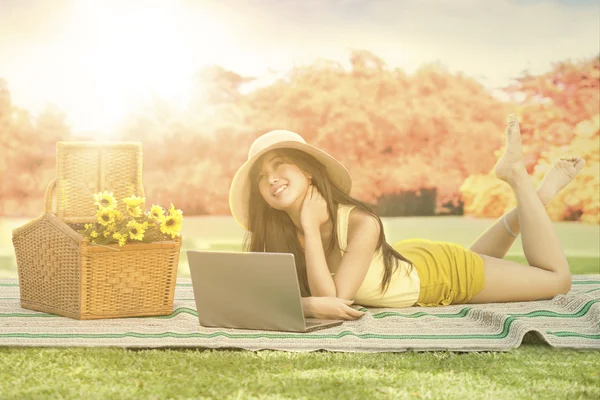 Mooi meisje met laptop ontspannen in herfst park — Stockfoto