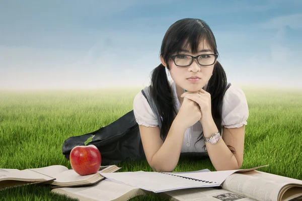 Cute Chinese student lying on grass — Stock Photo, Image