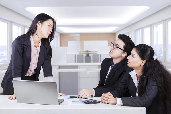 Empresária debatendo com sua equipe — Fotografia de Stock