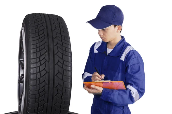 Mechanic with tires and clipboard — Stock Photo, Image