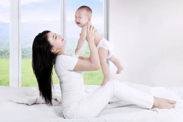 Mother throws up her baby — Stock Photo, Image