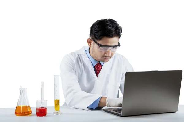 Wetenschapper werken met laptop en chemie — Stockfoto