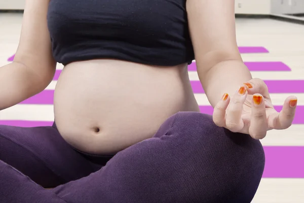 W ciąży brzuch i ręka pozować w medytacji — Zdjęcie stockowe