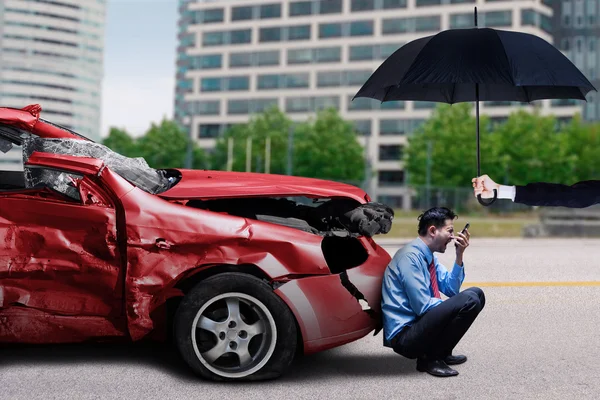 Frustrierter Mann mit beschädigtem Auto und Regenschirm — Stockfoto