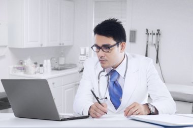 Dizüstü bilgisayar ile klinikte çalışan doktor