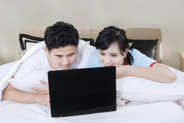 Par med laptop i sovrummet — Stockfoto