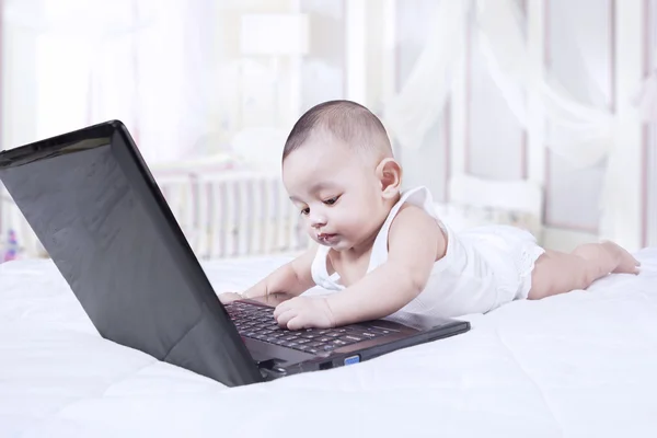 Любопытный ребенок играет с ноутбуком — стоковое фото