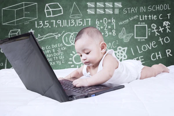 Lindo niño con portátil y garabatos — Foto de Stock