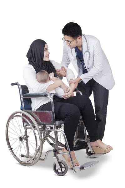 Врач помогает матери-инвалиду — стоковое фото