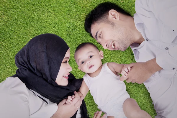 Muslim family lying down on grass — Stock Photo, Image