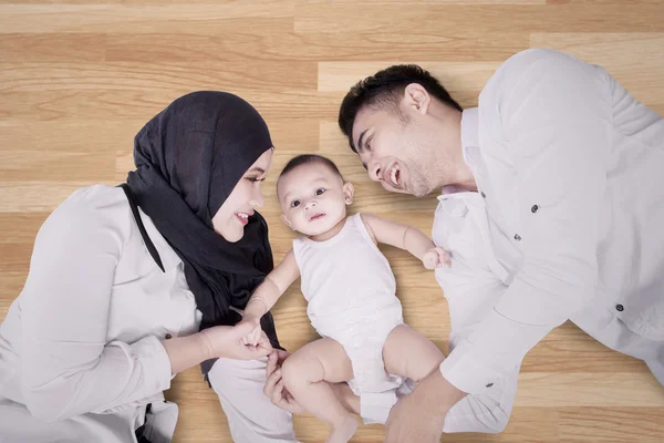 Moslim familie liggend op de houten vloer — Stockfoto