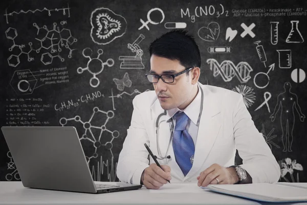 Physician with laptop and doodles — Stock Photo, Image