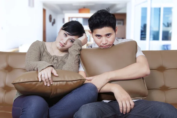 Jovem casal parece entediado no sofá — Fotografia de Stock