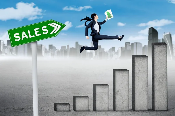 Businesswoman leaps on sales graph — Stock Photo, Image