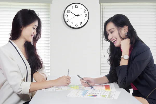 Cheerful workers with financial chart on desk — Stock Photo, Image