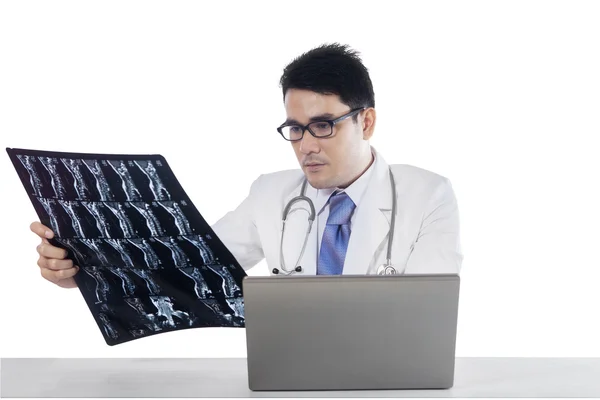 Arzt mit Laptop schaut auf Röntgenbild — Stockfoto