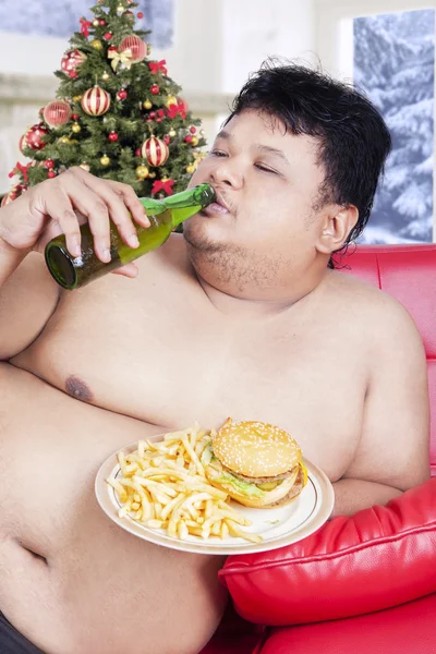 Grasso uomo godere fast food nel giorno di Natale — Foto Stock