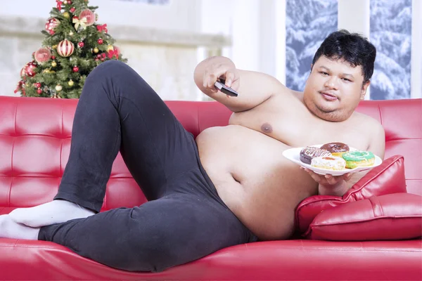 Fat man watching tv in christmas day — Stock Photo, Image