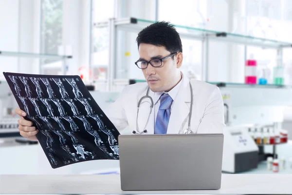 Läkare med röntgen och laptop i laboratorium — Stockfoto