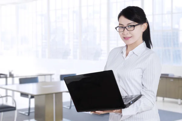 Mooie werknemer permanent in kantoor met laptop — Stockfoto