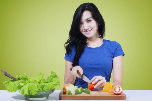 Vegetarische meisje snijden groente — Stockfoto