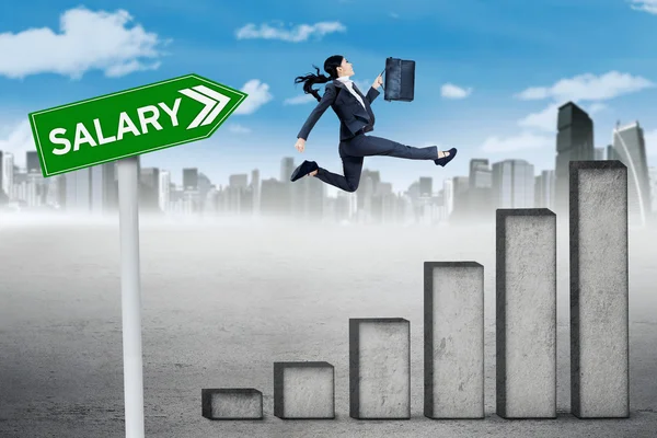 Worker jumps with chart and salary word — Stock Photo, Image