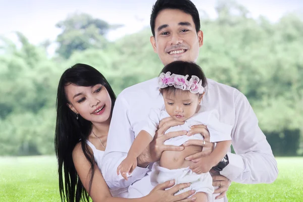 Los padres jóvenes y su hija en el parque — Foto de Stock