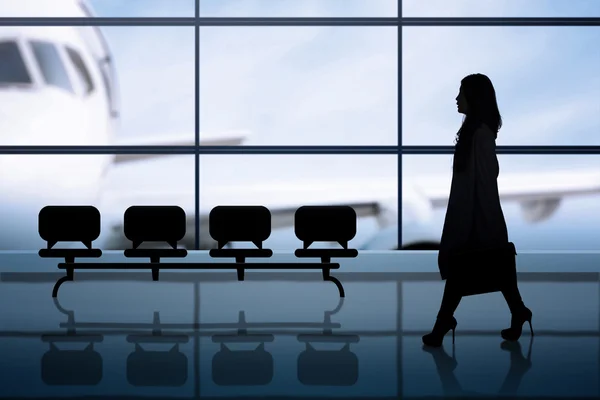 Vrouwelijke passagier wandelingen in luchthaven Stockfoto