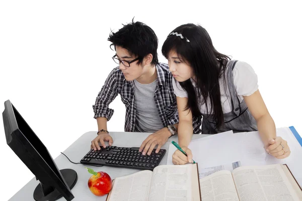 两个学生使用电脑在桌子上 免版税图库图片
