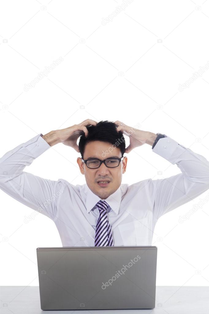 Stressful man with laptop and scratching head