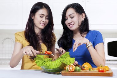 İki genç kız salata yapar