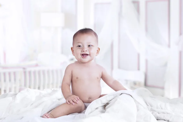 Schattige Aziatische baby lachen in de slaapkamer — Stockfoto