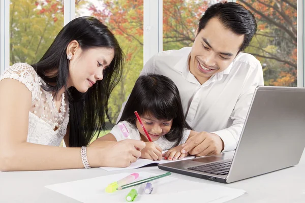 Female child studying with her parents — Stock Photo, Image