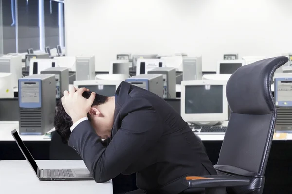 Empresário deprimido com laptop na mesa — Fotografia de Stock