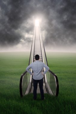 Genç işadamı tarafından bir yürüyen merdiven daimi