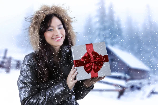 Donna con confezione regalo in giorno nevoso — Foto Stock