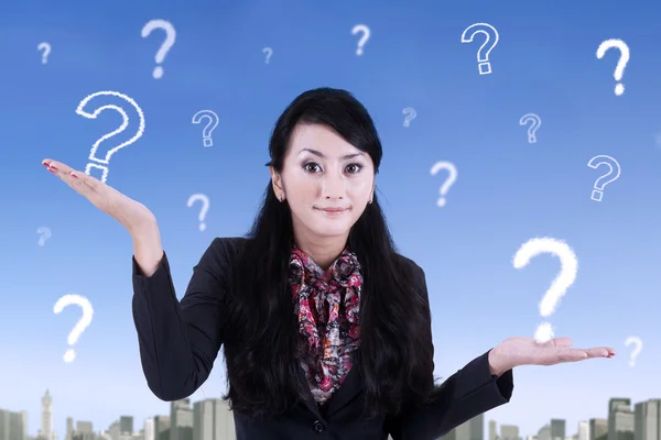 Young businesswoman and question marks — Stock Photo, Image
