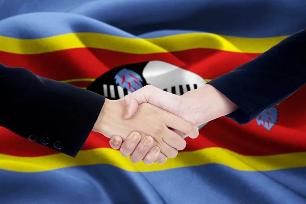 Friendship handshake with flag of Swaziland — Stock Photo, Image